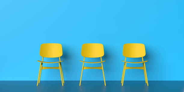 Three yellow chairs on blue background stock photo