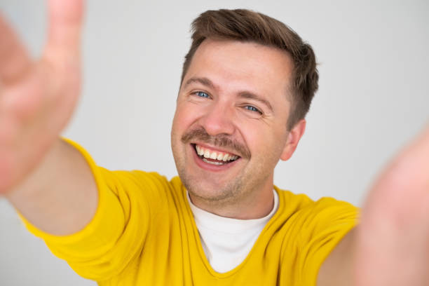 istock Handsome young man makes self, smiling broadly, on a gray background 1445021658