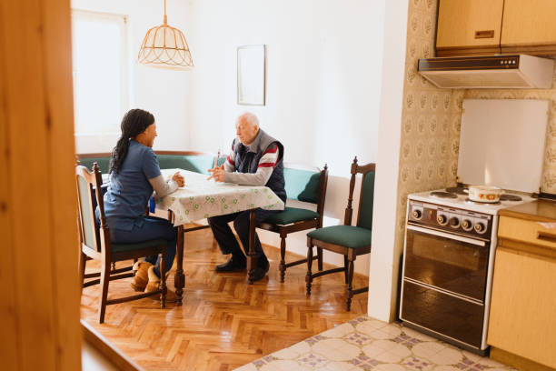 istock Friendly nurse talking to senior male patient 1445021887