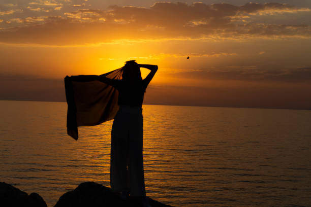 istock A female tourist making a victory sign at sunset. 1445022845
