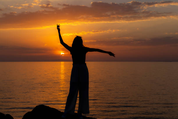 istock A female tourist dancing at sunset. 1445023054