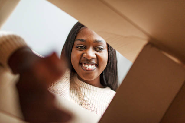 istock Young African woman opening box with gift 1445023927
