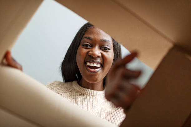 istock Young African woman opening box with gift 1445023938