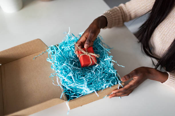 istock Young African woman receiving gift box 1445023985