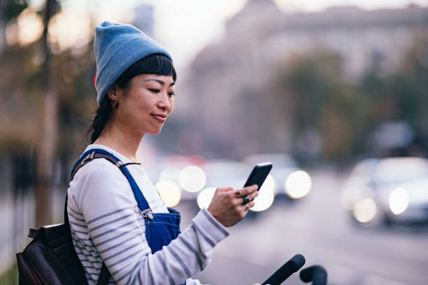istock Smiling Woman Using A Mobile Phone In The City 1445023994