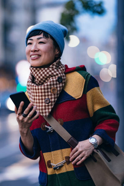 istock Smiling Woman Using A Mobile Phone Outdoors 1445024117