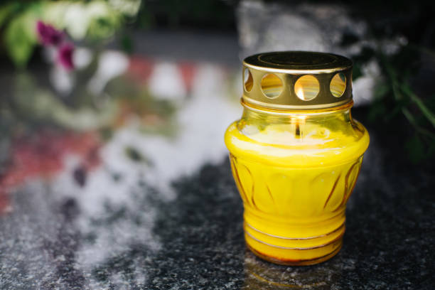 Marble stone background. Yellow grave candle.