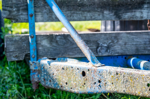 Rusted and worn down flat bed trailer with weeds overgrowing. . High quality photo