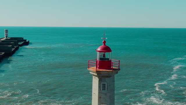 Drone view of Lighthouse Felgueirasin Porto with waves and cityscape, sunny day