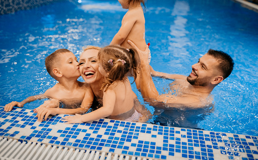 The family swims in the pool