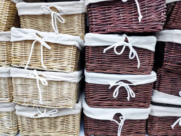 Photo of Colorful stack of wicker baskets boxes for towels and home stuff on shelf in bathroom. interior background concept.