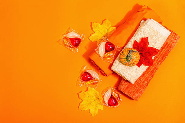 istock Machine washing concept. Capsules with detergent, soft towels and autumn decor. Laundry pods 1445038794