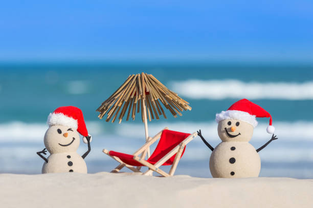 istock Two Sandy Christmas Snowmen on the beach 1445039664