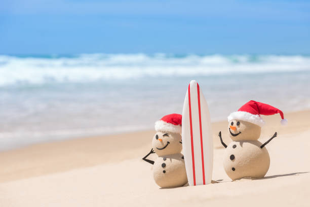 istock Two Sandy Christmas Snowmen with a surf board 1445039713