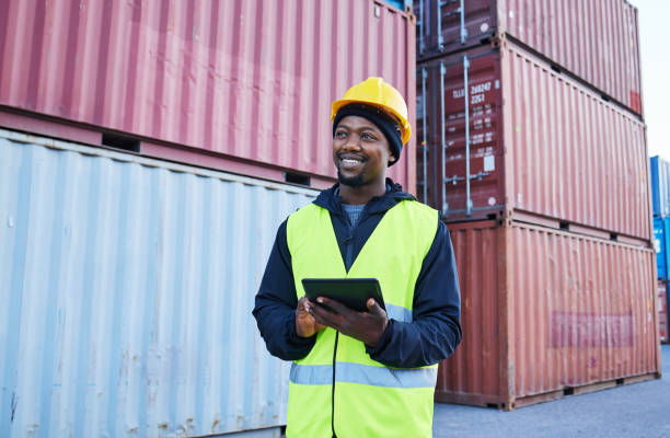 istock Tablet, logistics and shipping with a supply chain black man manager working on a commercial container dock outside. Internet, freight and cargo with a male courier at work in an export storage yard 1445043399