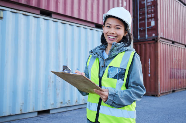 istock Logistics, inspection and worker working at shipping warehouse and doing inventory check while at work at port. Portrait of an Asian construction employee with smile and notes on manufacturing stock 1445043408