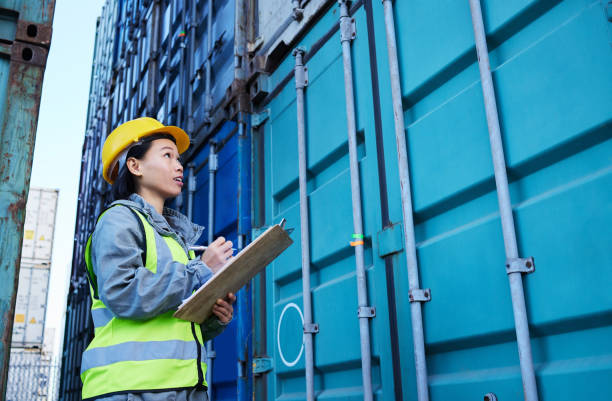 istock Storage shipping container, cargo worker and logistic woman employee with data. Construction and stock logistics asian manager planning, writing and working on export numbers and information 1445043467