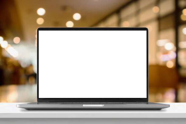 istock Laptop with blank screen on marble table with cafe coffee shop blur background 1445044542