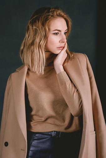 Portrait of young attractive pretty blonde woman in the beige jacket