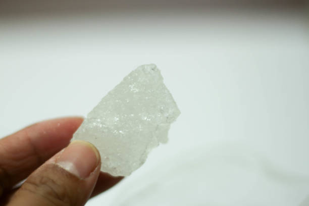 istock hand holding rock sugar or white rock sugar isolated on white background. 1445054974