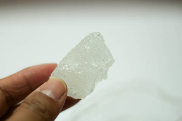 istock hand holding rock sugar or white rock sugar isolated on white background. 1445054976