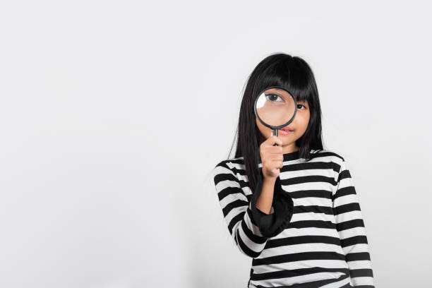 istock Asian little kid 10 years old funny looking through magnifying glass 1445060402