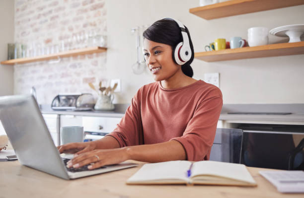 istock Email, music and black woman typing on the internet on a laptop while working at a table in her house. Remote African worker planning on web with technology while listening to a podcast in her home 1445073149