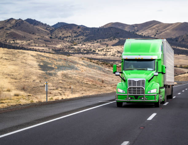 green semi truck moves down the road
