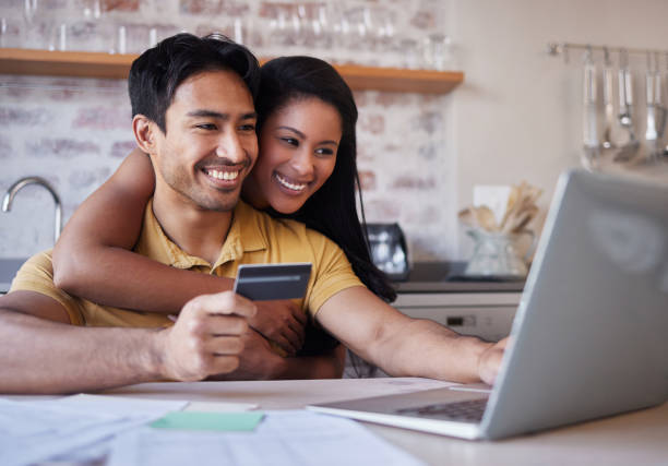 istock Laptop, credit card and finance with an accounting couple using a computer for ecommerce in the kitchen of their home. Money, savings and investment with a man and woman making an internet purchase 1445074334