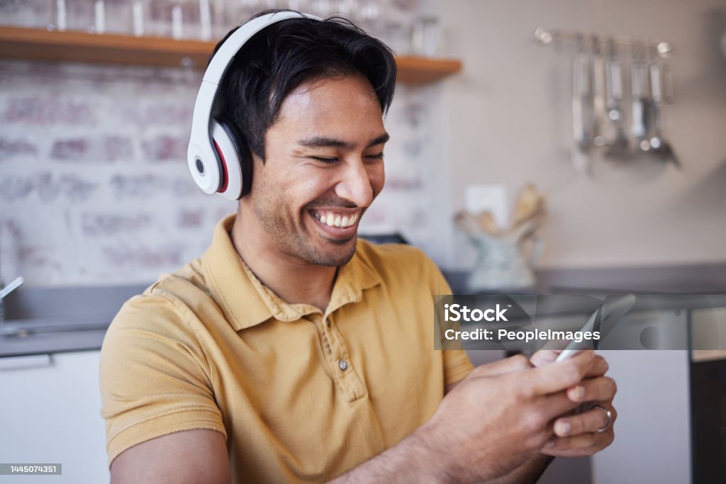 Phone, music and man on social media laughing at a funny joke on a podcast, network app or video streaming website. Smile, meme and happy Asian person sharing trendy online content to relax at home 30-34 Years Stock Photo