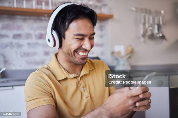 Phone Music And Man On Social Media Laughing At A Funny Joke On A Podcast Network App Or Video Streaming Website Smile Meme And Happy Asian Person Sharing Trendy Online Content To Relax At Home Stock Photo - Download Image Now