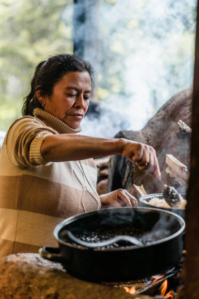 전통적인 장작 난로에서 시골 공동체의 여성. - ethnic food 뉴스 사진 이미지