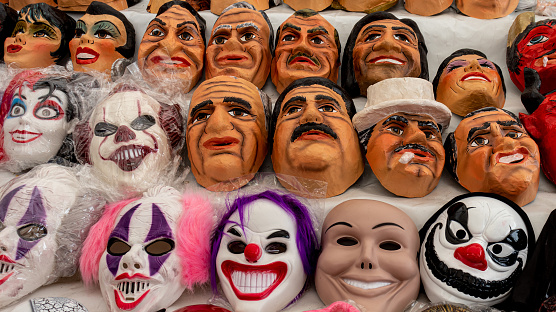 Cuenca, Ecuador - December 28, 2021: Fun, comedian and political masks for sale at the street market for Monigotes or Paper Mache dummies to be burn out to celebrate New Year's Eve