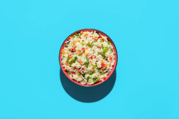 Fried rice bowl above view on a blue background