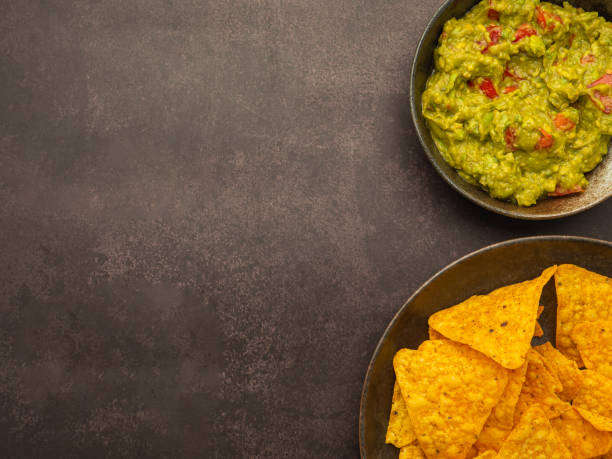 istock Fresh guacamole and tortilla chips on a plate on a brown background with copy space for text. Top view. Concept of traditional Mexican foods and healthy fruits 1445078474
