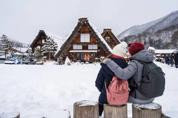 Young couple traveler enjoying with snow at shirakawa-go in winter