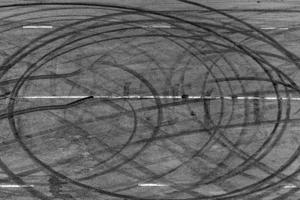istock Top view tire tracks texture and background, Asphalt texture with line and tire marks, Automobile automotive tire skid mark on race track, Abstract texture car drift tire skid mark. 1445085702