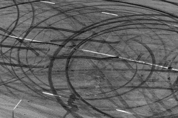 istock Top view tire tracks texture and background, Asphalt texture with line and tire marks, Automobile automotive tire skid mark on race track, Abstract texture car drift tire skid mark. 1445085729