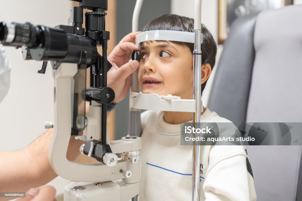 Child Being Examined At The Ophthalmologist Schoolchild's Eye Vision İs Checked. Eye Test And Close Lamp Examination Are Performed. Eye Exam Stock Photo