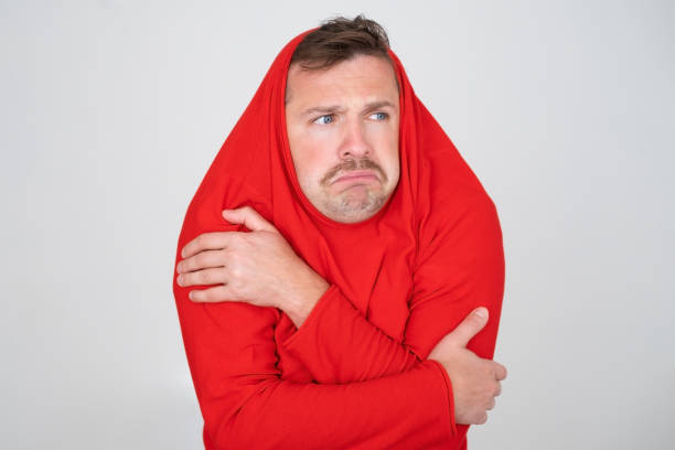 istock man ihiding pulling sweater on head in displeasure, keeps arms folded. 1445095378