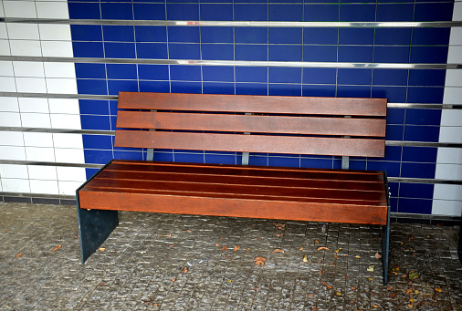 A single blue bench sits in a park, waiting for someone to come and sit down.