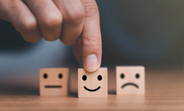 istock Close up customer hand choose smile face and blurred sad face icon on wood cube, Service rating, Customer service evaluation and satisfaction survey concepts. 1445100007