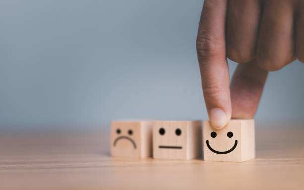 istock Close up customer hand choose smile face and blurred sad face icon on wood cube, Service rating, Customer service evaluation and satisfaction survey concepts. 1445100569