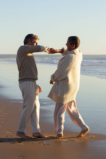 istock Romantic senior couple spending time at seashore at sunset 1445103221