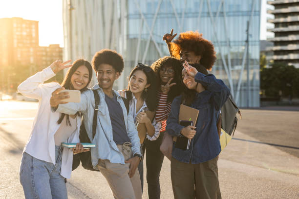 istock Group of multiracial students taking a selfie and making peace symbol with hands in the university campus. Focus on african american boy 1445103838