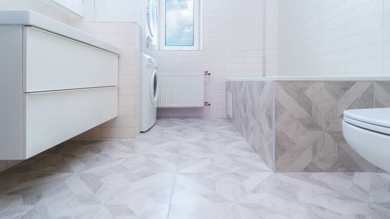 Bathroom renovation before and after. Laying new stone tiles in modern bath room. Comparison view of floor reconstruction