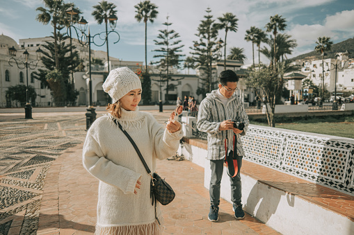 Asian Chinese Tourist couple in front of old town Tetouan, Morocco during sunset