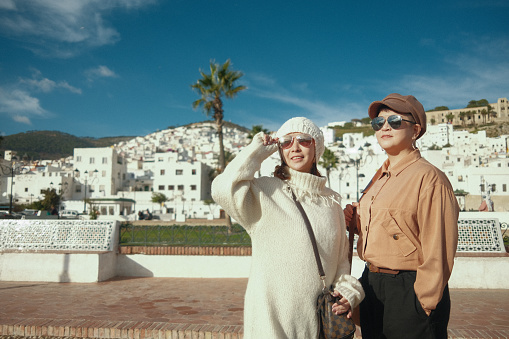 Asian Chinese Female Tourist in front of old town Tetouan, Morocco during sunset