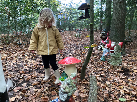 Toddler girl  siting on a playground mushroom .