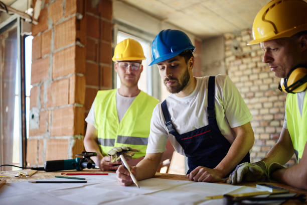istock Team of manual workers examining housing project while working at construction site. 1445110037
